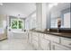 Bright bathroom featuring a soaking tub under a window, vanity with dual sinks, and separate glass enclosed shower at 12399 Lynnwood Blvd, Carmel, IN 46033