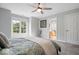 Spacious bedroom with a glimpse into an adjacent kitchen, featuring a ceiling fan and natural light at 12399 Lynnwood Blvd, Carmel, IN 46033