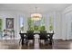 Dining room with dark wood table, modern chandelier, and many windows at 12399 Lynnwood Blvd, Carmel, IN 46033
