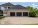 Attached three-car garage with black doors and concrete driveway at 12399 Lynnwood Blvd, Carmel, IN 46033