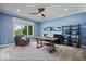Bright blue home office equipped with shelving, a desk, comfortable chair, and natural light from a window at 12399 Lynnwood Blvd, Carmel, IN 46033
