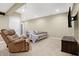 Finished basement featuring neutral carpeting, recessed lighting, a gray couch, and a brown recliner at 125 W Chalet Dr, Mooresville, IN 46158