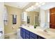 Well-lit bathroom with a double sink vanity, blue cabinets, and a full-sized mirror at 125 W Chalet Dr, Mooresville, IN 46158