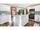 Bright kitchen features an island with marble countertop, stainless steel appliances, and decorative backsplash at 125 W Chalet Dr, Mooresville, IN 46158