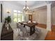 The dining room is staged with a wood table, upholstered chairs and an elegant chandelier at 1297 Morningside Dr, Greenfield, IN 46140