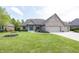 Beautifully landscaped brick home featuring an attached three car garage and a bright blue front door at 1297 Morningside Dr, Greenfield, IN 46140