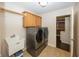 Modern laundry room features a new washer and dryer, with functional upper cabinets and a utility sink at 1297 Morningside Dr, Greenfield, IN 46140