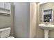 Bathroom features a pedestal sink, cabinet, and a toilet with neutral colored walls at 13499 Molique Blvd, Fishers, IN 46037
