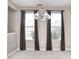 Bright dining area with neutral walls, chandelier, and large windows with dark curtains at 13499 Molique Blvd, Fishers, IN 46037