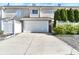 Tan townhouse with an attached one-car garage, landscaping, and a long driveway at 13499 Molique Blvd, Fishers, IN 46037