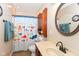 Charming bathroom featuring wood vanity, large mirror, and colorful shower curtain at 1426 S Anderson St, Elwood, IN 46036