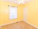Bright bedroom featuring neutral walls, ceiling fan, and large window at 1426 S Anderson St, Elwood, IN 46036
