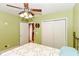 Comfortable bedroom featuring neutral walls, ceiling fan, and double door closet at 1426 S Anderson St, Elwood, IN 46036