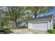 Detached two-car garage in a spacious backyard with mature trees and a well-manicured lawn at 155 N Franklin Rd, Indianapolis, IN 46219