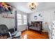 Charming Bedroom featuring a comfortable glider, crib, and hardwood floors at 155 N Franklin Rd, Indianapolis, IN 46219