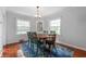 Dining room features wood table, hardwood floors, and natural light from bright windows at 155 N Franklin Rd, Indianapolis, IN 46219