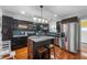 Bright kitchen with stainless steel appliances, island with seating, and hardwood floors at 155 N Franklin Rd, Indianapolis, IN 46219