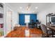 Well-lit home office featuring hardwood floors, built-in shelving, and multiple workstations at 155 N Franklin Rd, Indianapolis, IN 46219