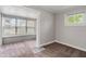 Bedroom with neutral walls, carpet, and large window with view to sun room at 1602 Villa Ave, Indianapolis, IN 46203