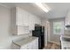 Well-lit kitchen features white cabinets, modern gray countertop and stainless steel refrigerator at 1602 Villa Ave, Indianapolis, IN 46203