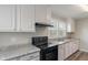 This clean kitchen features white cabinets, neutral countertops, and a black oven at 1602 Villa Ave, Indianapolis, IN 46203