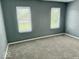 A bright bedroom features plush carpet flooring and large windows, creating a comfortable and inviting space at 1715 S Madison St, Muncie, IN 47302