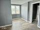 Bedroom featuring wood-look flooring, neutral-toned walls, and a window with blinds at 1715 S Madison St, Muncie, IN 47302