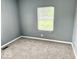 A bright bedroom features plush carpet flooring, a window overlooking the landscape, creating a serene and inviting retreat at 1715 S Madison St, Muncie, IN 47302