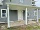 A close-up of the gray siding and white-columned front door and entryway at 1715 S Madison St, Muncie, IN 47302