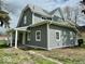Exterior side angle showcasing the home's gray siding, white trim, and covered porch with fresh landscaping at 1715 S Madison St, Muncie, IN 47302