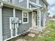 Side exterior view of a gray home with a white door, matching trim, and decorative porch columns near meters at 1715 S Madison St, Muncie, IN 47302