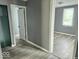 Hallway featuring wood-look flooring, neutral-toned walls, and multiple doors at 1715 S Madison St, Muncie, IN 47302