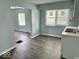A bright kitchen features sleek vinyl flooring, stainless steel sink, and white cabinets offering a functional and stylish design at 1715 S Madison St, Muncie, IN 47302