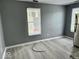 Living room space featuring modern gray flooring, multiple windows, and gray walls at 1715 S Madison St, Muncie, IN 47302