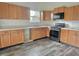 Kitchen featuring wood cabinets, stainless steel appliances, a modern faucet, and vinyl flooring at 2154 Walnut Meadow Ct, Indianapolis, IN 46234