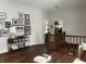 Upstairs hallway with hardwood floors, gallery wall, and a view into a bedroom at 2161 N Pennsylvania N St, Indianapolis, IN 46202