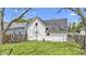 A well-maintained backyard featuring green grass, a wooden fence, and the home's exterior with white siding and a dark roof at 223 Grove St, Greenfield, IN 46140