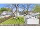 A spacious backyard offers an inviting outdoor space with a fire pit, seating area, shed, and lush lawn, perfect for relaxation at 223 Grove St, Greenfield, IN 46140