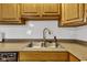 Kitchen sink with wooden cabinets, white tile backsplash, and modern faucet at 223 Grove St, Greenfield, IN 46140