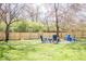 Wide, green backyard features a fire pit with modern outdoor seating surrounded by a wood fence at 2763 Streamside Dr, Columbus, IN 47203