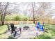 Green back yard features a gravel fire pit with black and colorful outdoor seating surrounded by a wood fence at 2763 Streamside Dr, Columbus, IN 47203