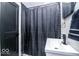 Modern bathroom featuring a shower with black tiled walls, shower curtain, and sleek vanity with black hardware at 2763 Streamside Dr, Columbus, IN 47203
