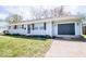 Charming single-story home with light blue siding, black shutters, and attached garage at 2763 Streamside Dr, Columbus, IN 47203