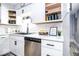 Kitchen counter featuring a black sink, stainless steel dishwasher, and decorative items, with open upper cabinets at 2763 Streamside Dr, Columbus, IN 47203