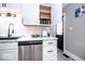 Kitchen counter featuring a black sink, stainless steel dishwasher, and decorative items, with open upper cabinets at 2763 Streamside Dr, Columbus, IN 47203