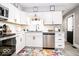 Well-lit kitchen with white cabinets, stainless steel dishwasher, subway tile backsplash, and black hardware at 2763 Streamside Dr, Columbus, IN 47203