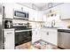 Modern kitchen featuring stainless steel appliances, white cabinets, subway tile backsplash and colorful floor rugs at 2763 Streamside Dr, Columbus, IN 47203