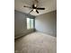 A cozy bedroom features neutral paint, a ceiling fan, and a large window for natural light at 2967 Eagles Crest Cir # C, Indianapolis, IN 46214