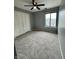 A cozy bedroom features neutral paint, ceiling fan, closet, and large window for natural light at 2967 Eagles Crest Cir # C, Indianapolis, IN 46214
