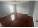 A light-filled bedroom offers hardwood floors and a bright window bringing in plenty of natural light at 317 Legacy Blvd, Greenwood, IN 46143
